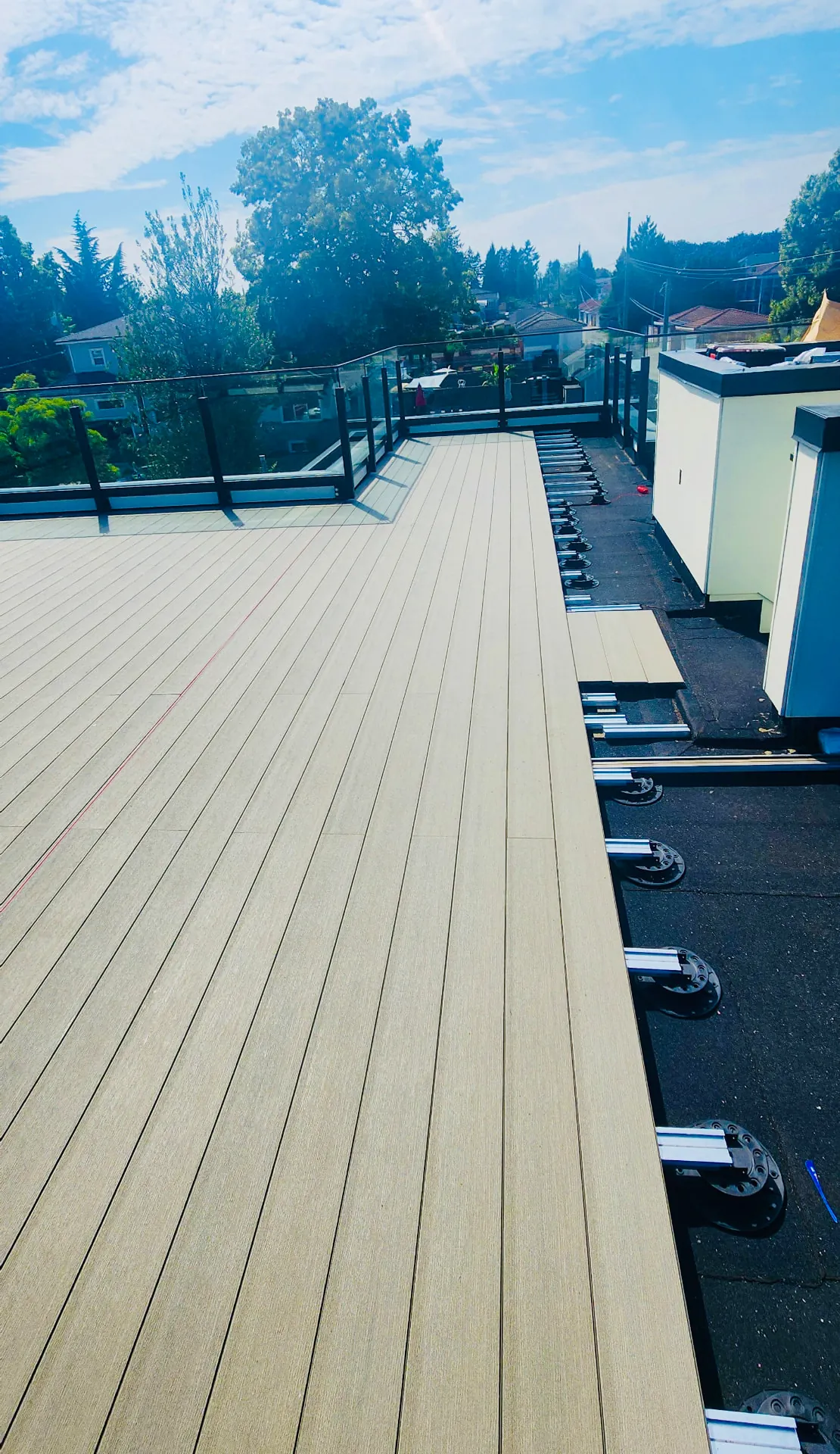 Board layout advancing across the rooftop, with the pedestal and joist corridor still open.