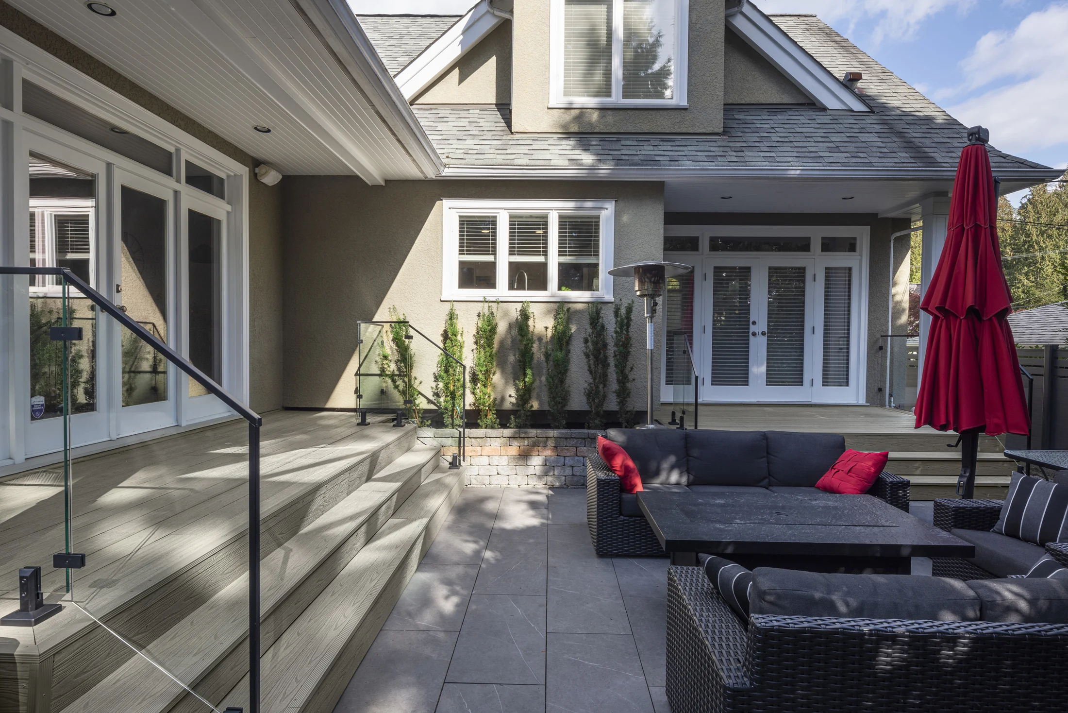 NeoLine composite deck with glass railing and outdoor seating beside a contemporary home