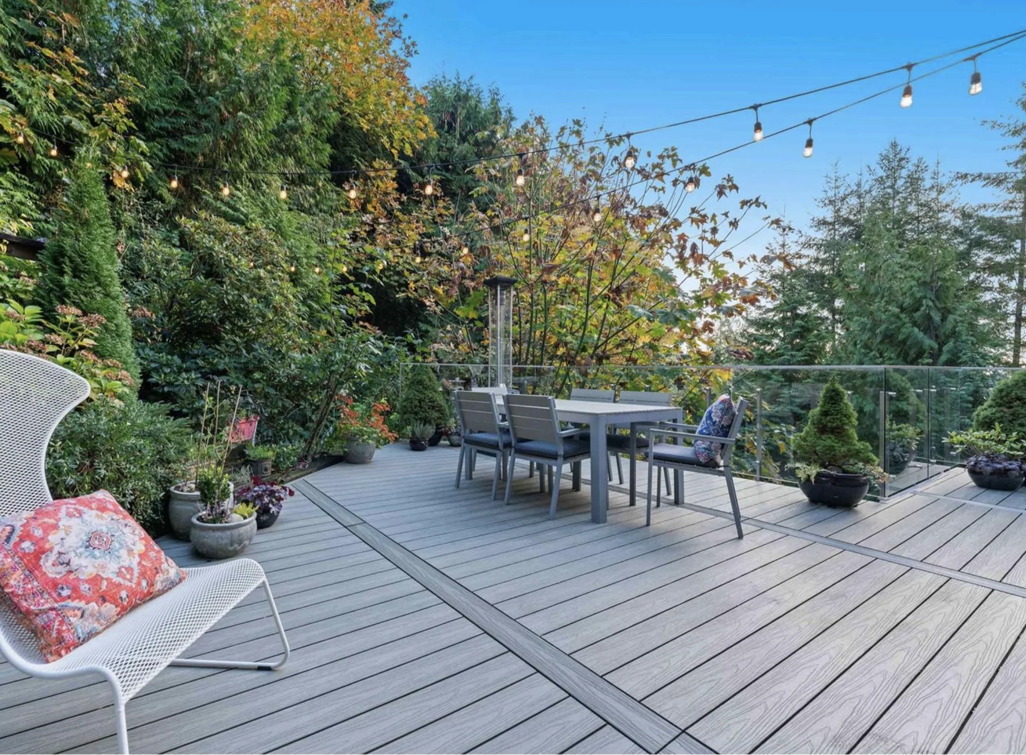 NeoLine composite deck with a dining table, lounge seating and surrounding greenery